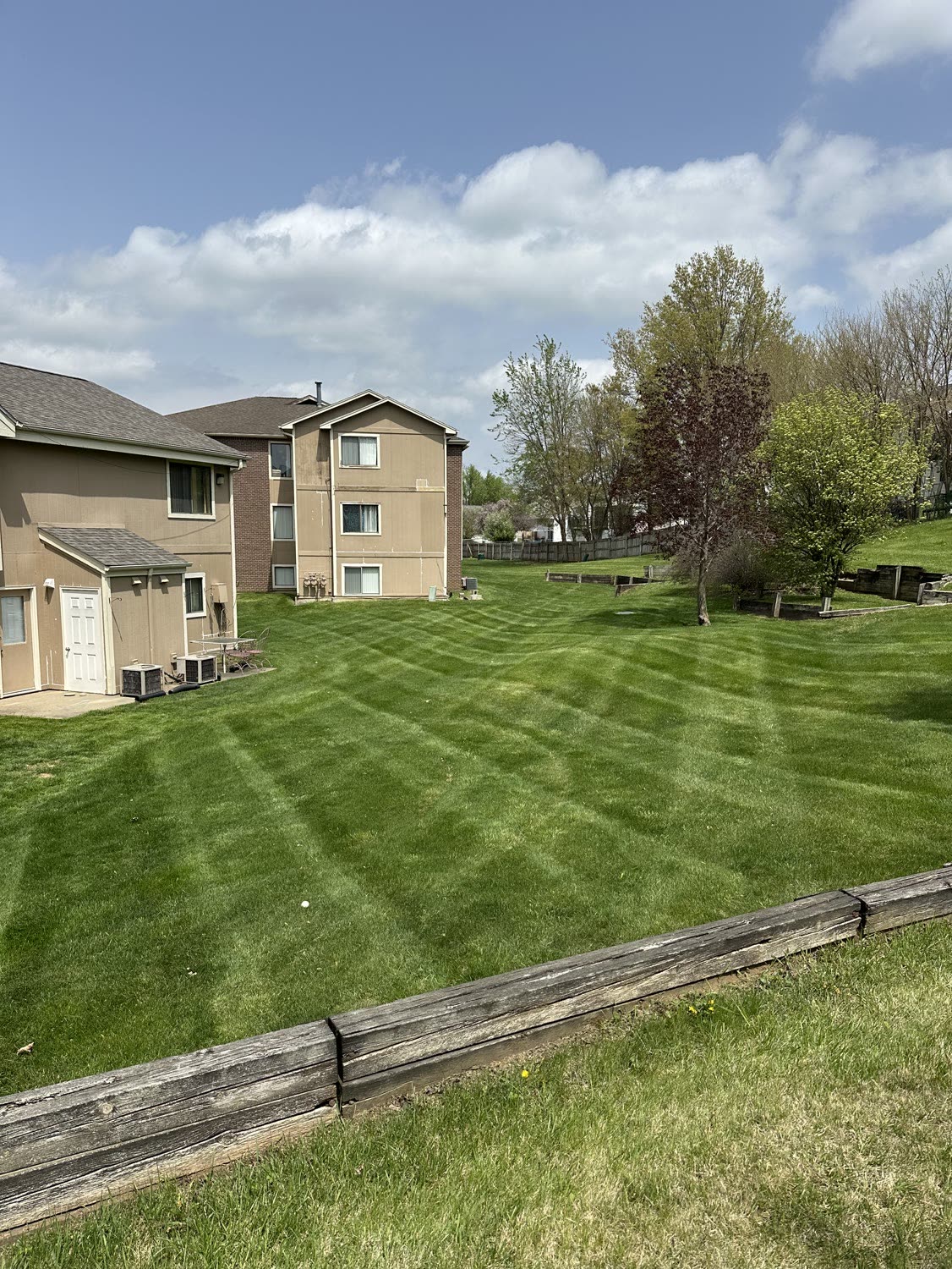 Striped lawn above a timber retaining wall at an apartment building