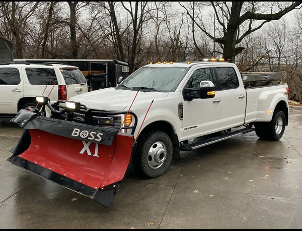 Dually pickup with a BOSS XT plow blade ready to go out
