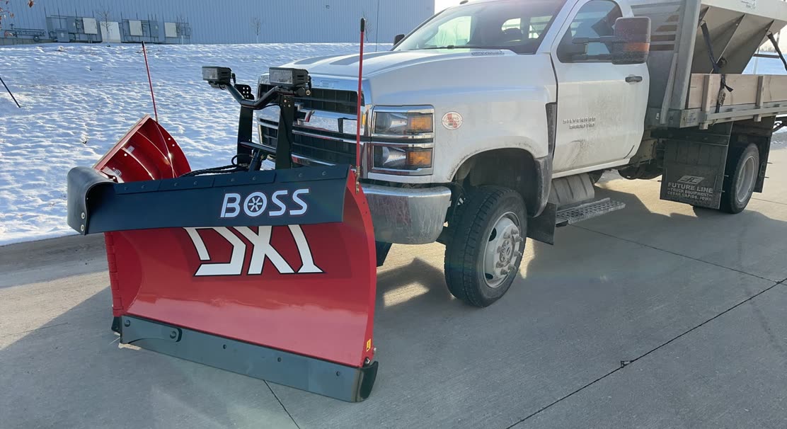 Plow truck with a salt spreader on a cleared lot